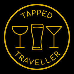 Tapped Traveller Portable Bar Services Logo.  Circle with tapped Traveller top centre and bottom centre with champagne glass, beer glass, martini glass outline entered on logo